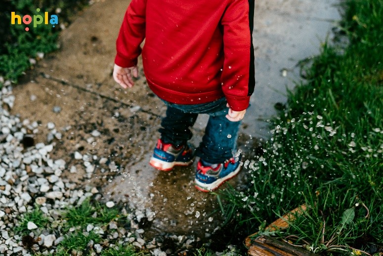 Chlapec skákajúci v kaluži